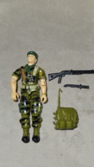 FALCON (v1) GREEN BERET 1987  with a green backpack with a green antenna, a black shotgun, and a black knife (that fit in the backpack).
